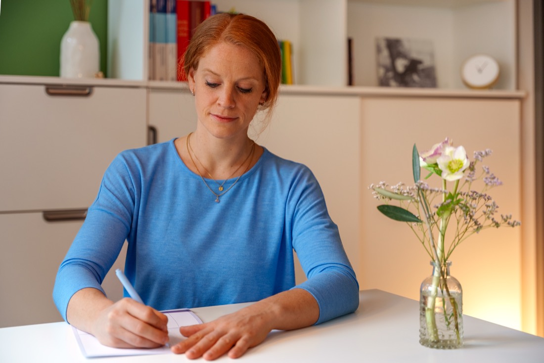 Kathrin Pesch macht sich am Schreibtisch Notizen zum Erstgespräch