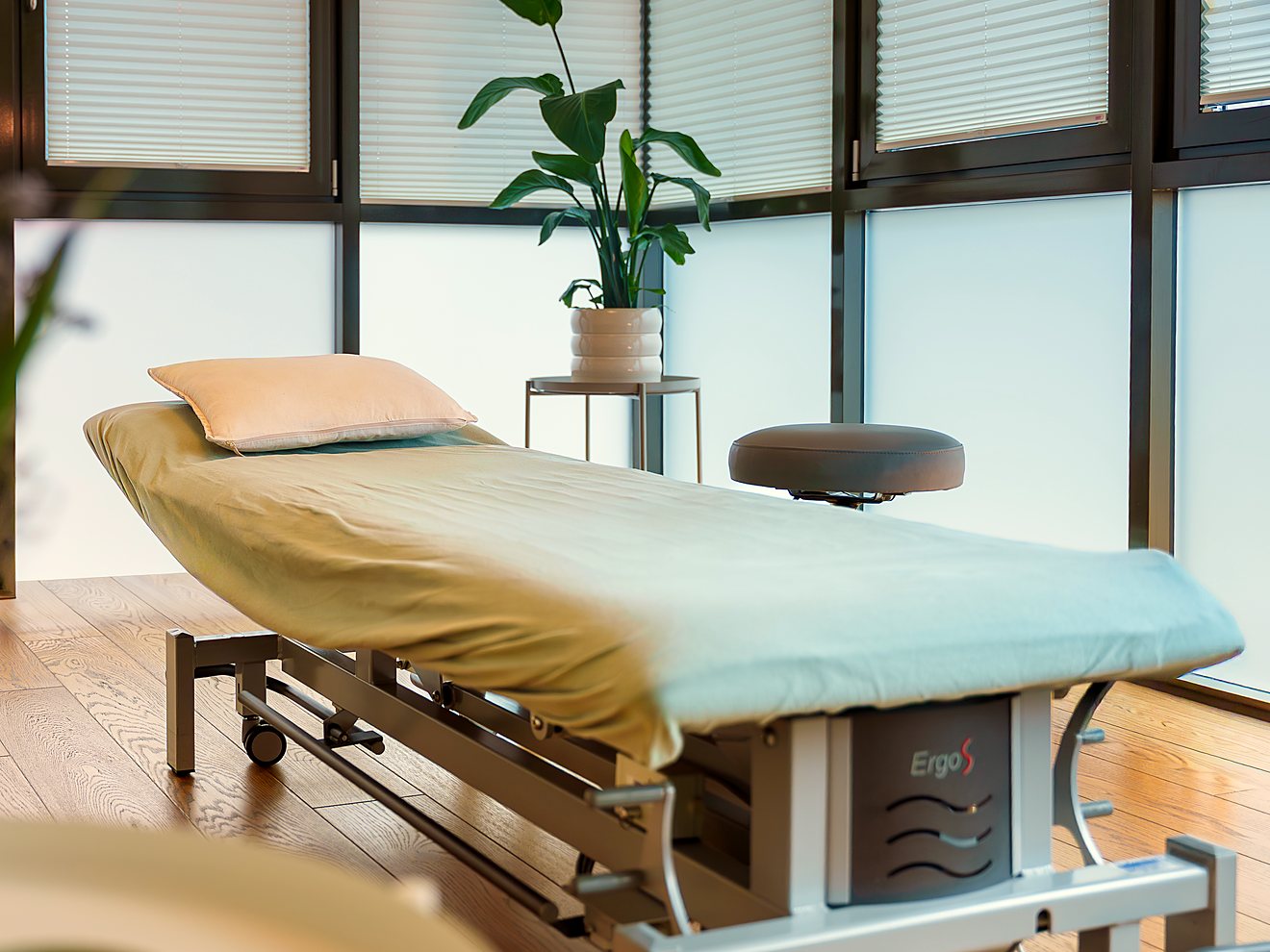 Heller Behandlungsraum mit Therapieliege in der Praxis